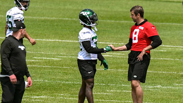 RB Michael Carter (32) and QB Aaron Rodgers (8) at Jets' OTAs